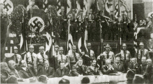 Heidegger, in his capacity as Rektor of the University of Freiburg, sits fourth from the right at a public demonstration of support for Nazism by German professors on 11 November 1933 in Leipzig.
